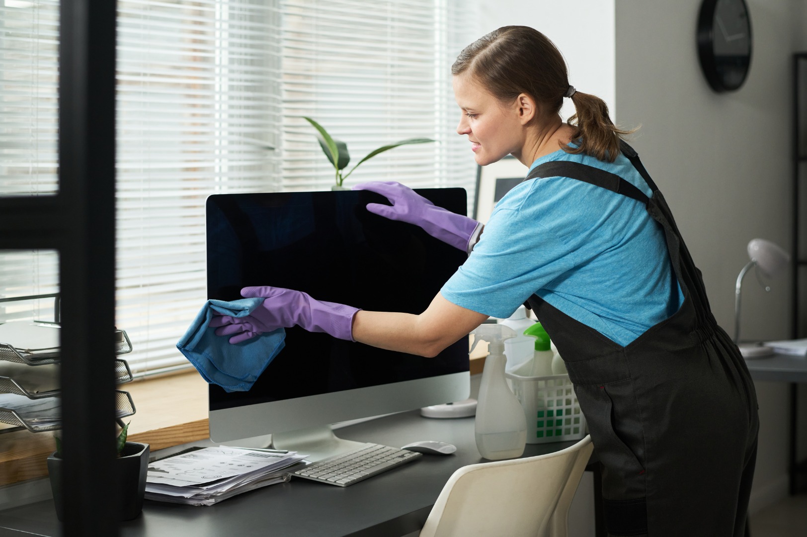 Cleaning specialist disinfecting an office workstation